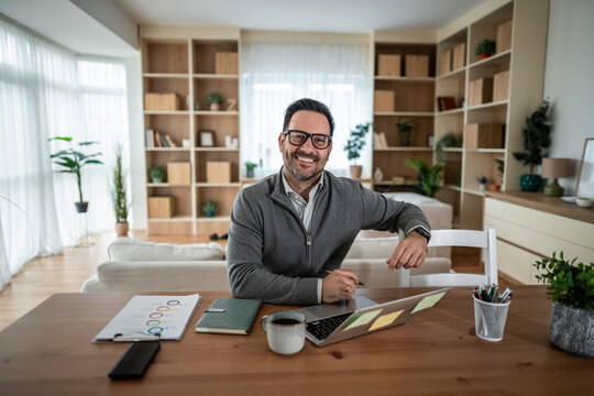 Happy man working from home smiling at camera - Powered by Adobe