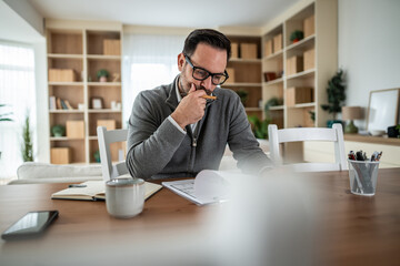 Man thinking while working from home with documents