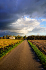 Obraz premium road in the field and stormy sky