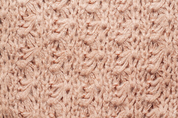 Close-up of a textured knitted fabric in a warm, neutral beige color