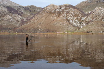 mountain lake in the morning and fisherman