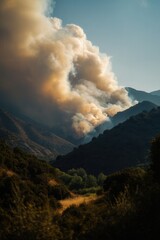 Fototapeta premium Thick smoke rises from a wildfire engulfing a mountain valley, highlighting nature's power and destruction. Ideal for news on climate change and environmental disasters.