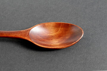 There is a wooden spoon on a black background.	