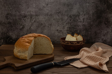 Homemade wheat bread lies on a cutting board on a wooden table. Food.