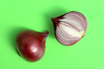 On a green background lies a purple onion cut in half.	