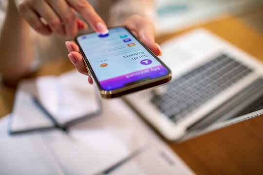 Adult focused on mobile banking at home office desk