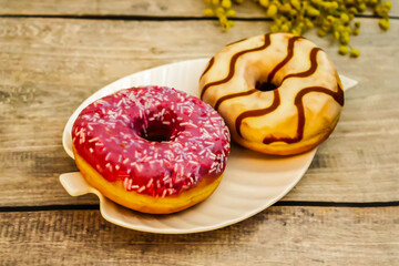 Two Delicious Glazed Donuts on a Wooden Table