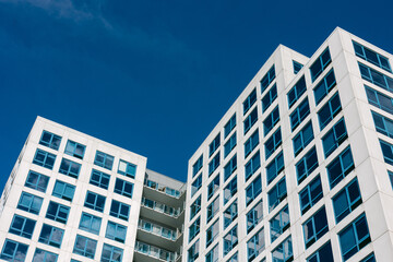 Modern architecture of sleek office buildings against a clear blue sky in an urban setting