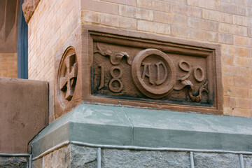 Historic stone carving showing the year 1890 on a building corner in an urban setting