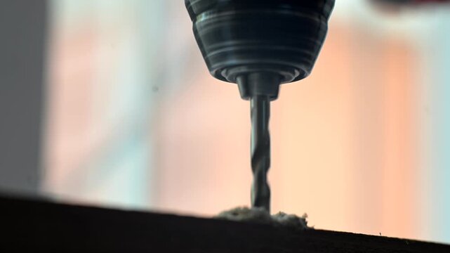 The power drill drilling into the wood and screwing in screws. Closeup