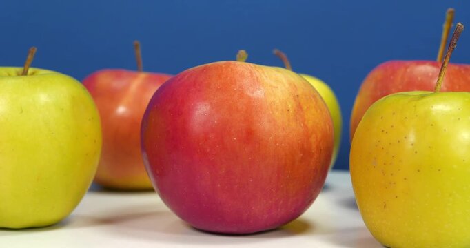 Fresh apples rotates on dark blue backdrop