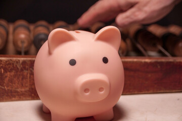 A small pink piggy bank sits on a wooden surface