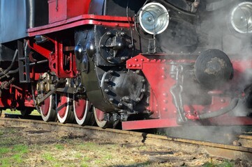 front part of an old steam locomotive on the railway close-up