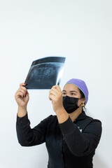 A woman dentist is reviewing a patient's X-ray to detect a mouth condition and perform surgery in a hospital office in Neiva, Huila, Colombia. Concept of health and dentistry