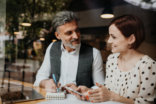 Man and woman having business meeting in a coffee shop. - Powered by Adobe