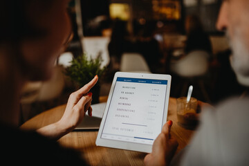 Tablet in hands during business meeting in a coffee shop.