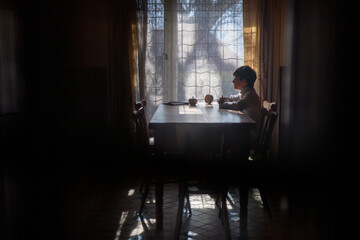 Poor sad orphan girl looking out of window.