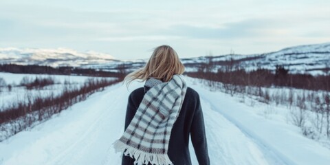 A woman is walking gracefully through a beautiful, snowy landscape, enjoying the serene atmosphere