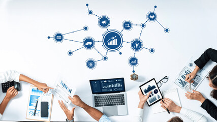 A modern office setting featuring a group of professionals engaged in business strategy and marketing analysis through data visualization and collaborative discussions. Amity