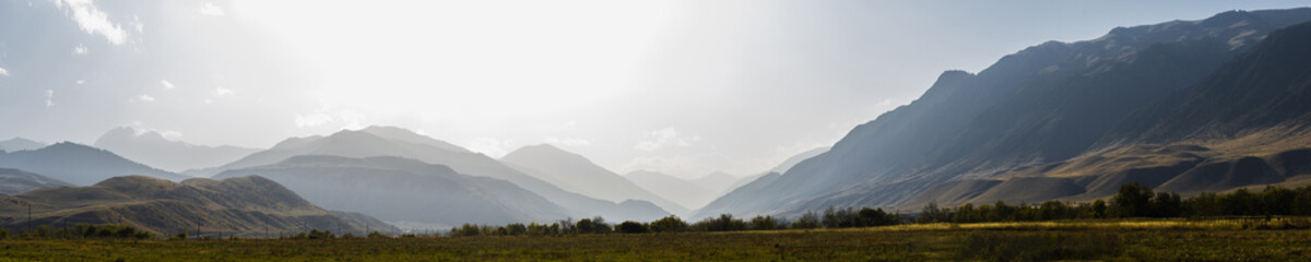 Majestic Kazakh landscape: snow-capped peaks, forested hills, and golden steppes in one frame.