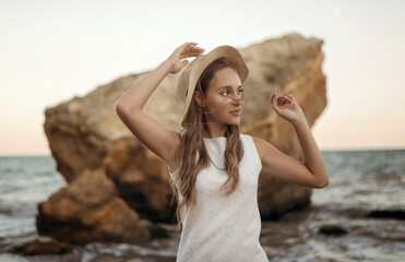 A person standing in front of a rock next to a body of water