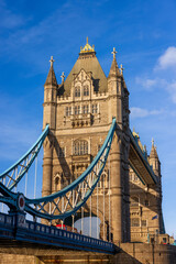 Obraz premium Close-up of London's iconic Tower Bridge with a red bus, under a clear blue sky.