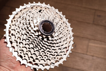 Close-up of a hand holding a multi-sprocket bicycle cassette showing gear progression and hub interface