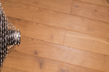 Close-up of a multi-sprocket rear cassette, partially visible on wood background
