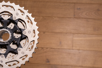 Close-up of a multi-sprocket rear cassette mounted on a bicycle hub, partially visible on wood background