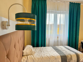 Bedroom interior with golden teal lamp and bed