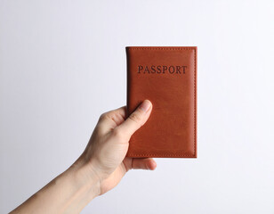 Hand Holding Brown Leather Passport Cover Against a Clean White Background.
