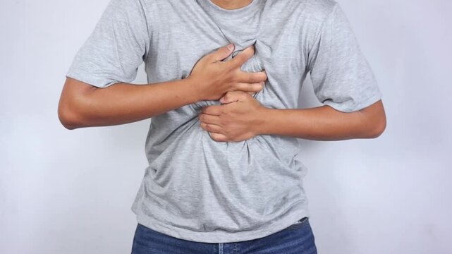 Chest pain. A man's hand is holding his chest. A man in pain is massaging the affected area. Heart attack, myocardial infarction or ischemia, myocarditis, pneumonia, shortness of breath. Emergency
