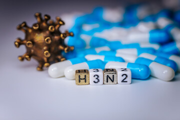 Colorful capsules and H3N2 letters are arranged artistically with a virus model in the background, symbolizing health, medicine, and the fight against illness and disease