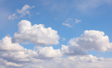 Blue sky with white fluffy cumulus clouds on sunny day