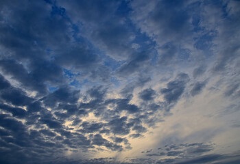 Dark patchy clouds covering blue sky at twilight