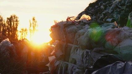 Sunrise over a landfill showing plastic waste and environmental impact