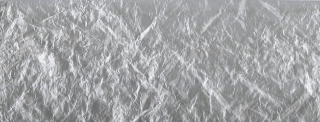 Crumpled transparent plastic texture. A wrinkled, clear plastic surface showcasing light reflections and detailed folds, ideal for abstract backgrounds.
