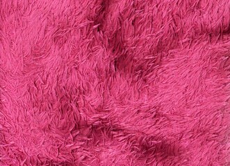 Vibrant pink fluffy fabric texture. Soft, shaggy, and cozy background, ideal for creative designs, fashion, or abstract themes.