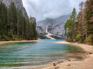 Scenic view of Lago di Braies in the Dolomites, Italy. Turquoise alpine lake surrounded by pine forests and sandy shoreline. Hiking destination in South Tyrol