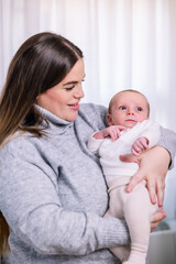 Young mother holding tiny newborn baby with love