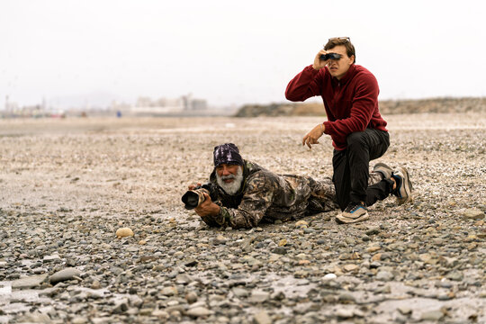 Bird watchers observing nature with camera and binoculars