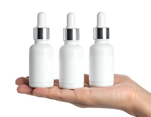 Three white dropper bottles held in hand