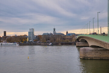 Fototapeta premium View of riverside buildings and bridge in a city during overcast evening hours