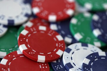 Close up of a group of casino chips on a green mat for poker or dice games indoors