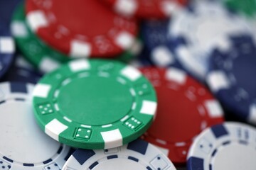 Close up of a group of casino chips on a green mat for poker or dice games indoors
