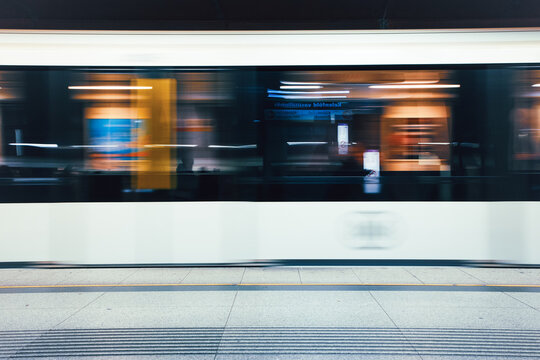 A high-speed metro train captured with strong motion blur as it passes through an urban station in Budapest, Hungary