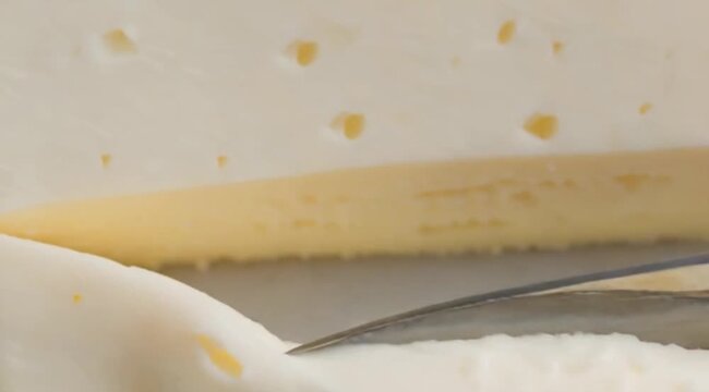 Cutting the fresh butter with knife. butter with large holes close up