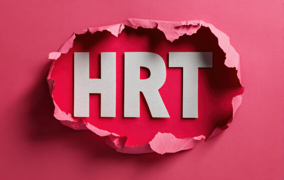 Hormone replacement therapy hrt text cut through pink paper symbolising women’s health and menopause