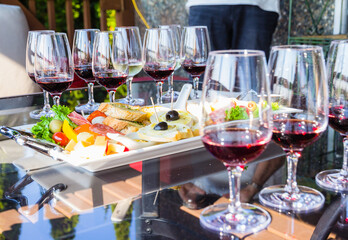 red wine in tasting glasses lined up with some snacks