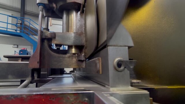 Industrial press brake machine bending sheet metal in a factory.